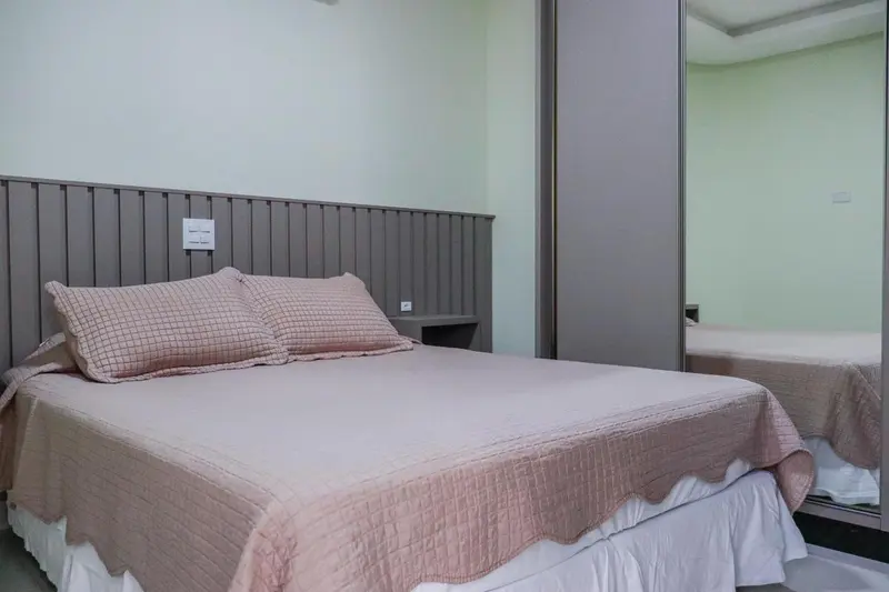 Une chambre avec un grand lit recouvert d'une courtepointe et de coussins.