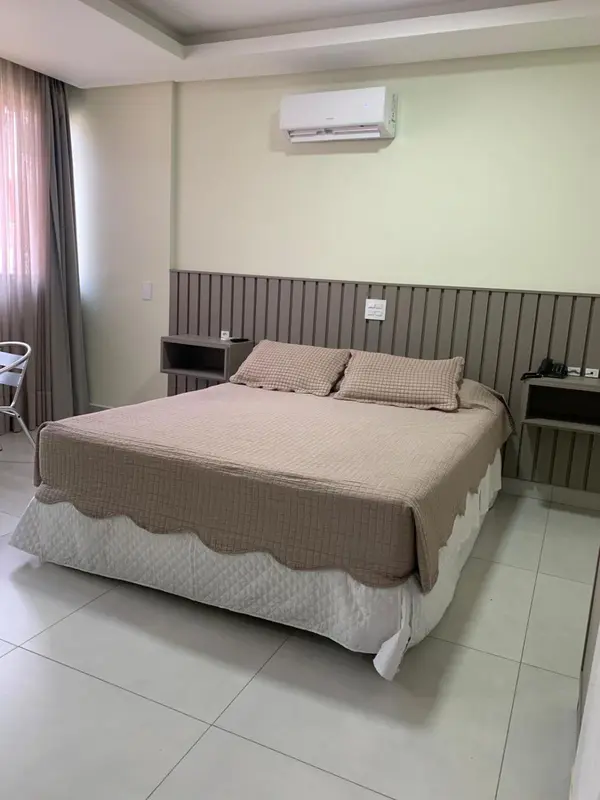 Une chambre avec un grand lit recouvert d'une courtepointe et d'oreillers.