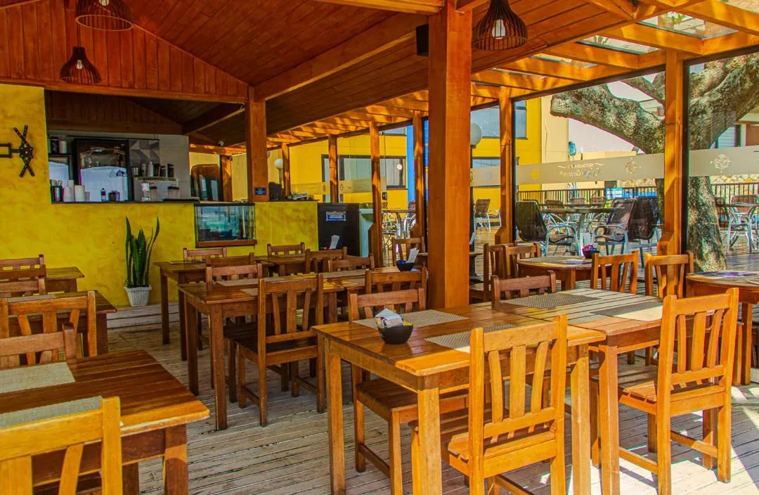 Une salle à manger lumineuse avec des tables en bois et des chaises.