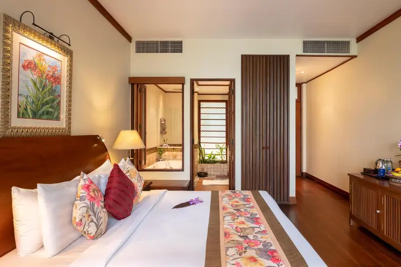 Une chambre lumineuse avec un grand lit et un accès à une salle de bain.