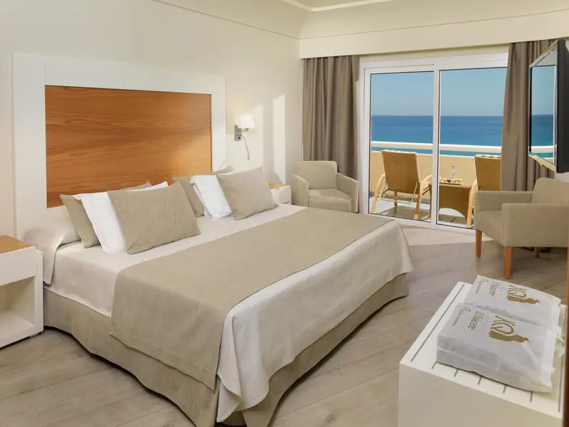 Une chambre lumineuse avec un grand lit et un accès à une terrasse.