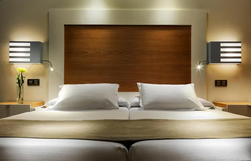 Un lit double avec des oreillers blancs dans une chambre lumineuse.