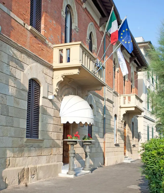 Façade d'un bâtiment avec un auvent blanc et des drapeaux.