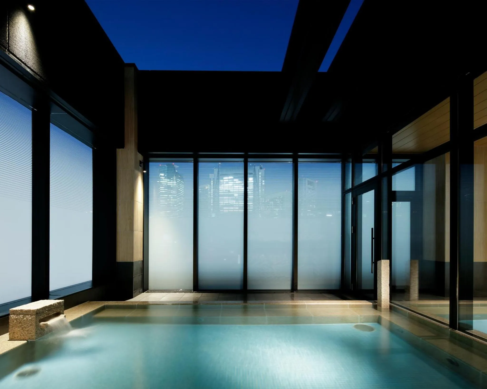 Une piscine intérieure lumineuse avec de grandes baies vitrées.