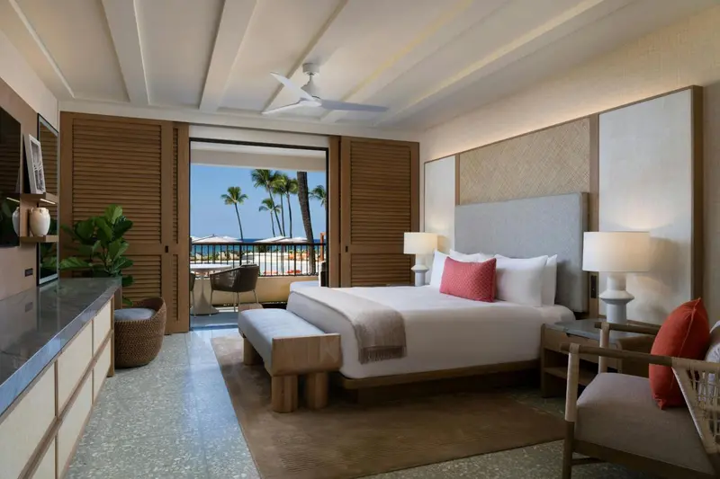 Une chambre lumineuse avec un grand lit donnant sur une vue sur la mer.