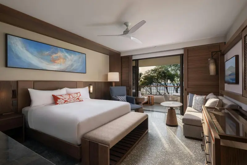 Une chambre lumineuse avec un grand lit et un coin salon.