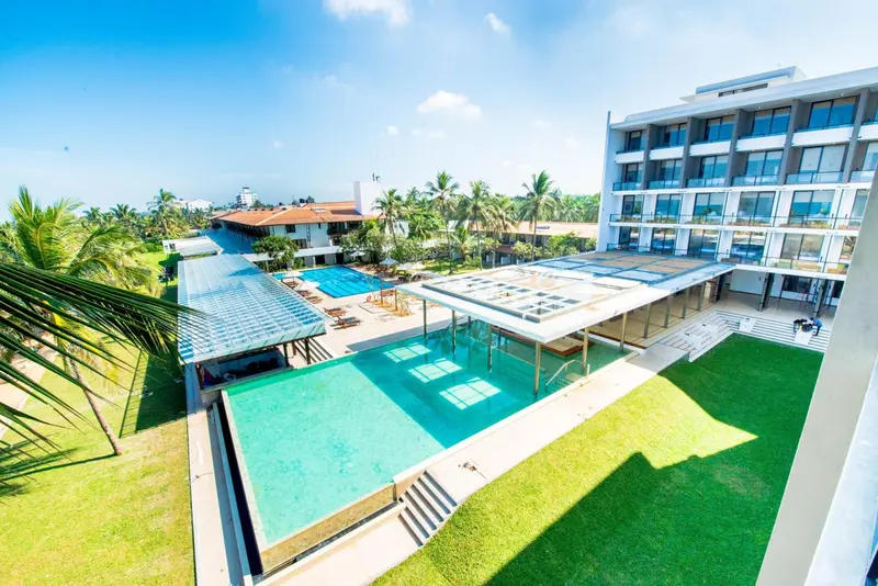 Vue aérienne d'un complexe hôtelier avec piscine et végétation luxuriante.