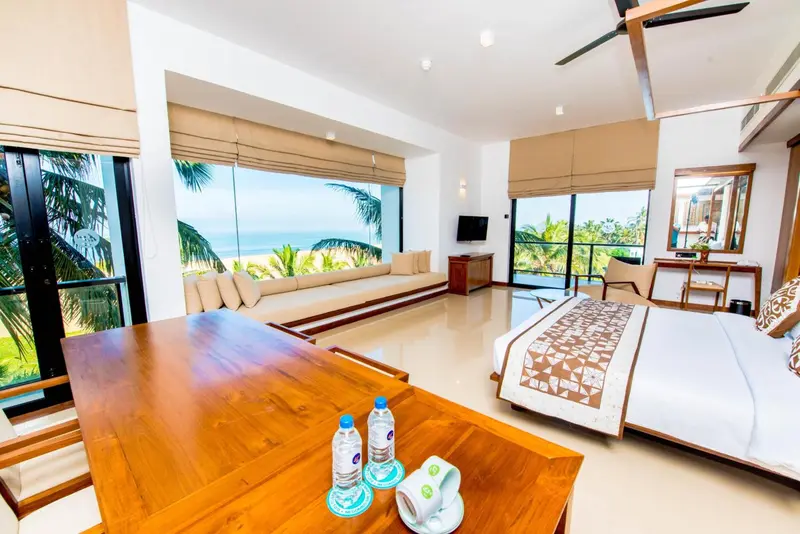 Espace de vie lumineux avec vue sur la mer et mobilier en bois.