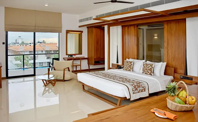 Une chambre lumineuse avec un grand lit et un coin salon.