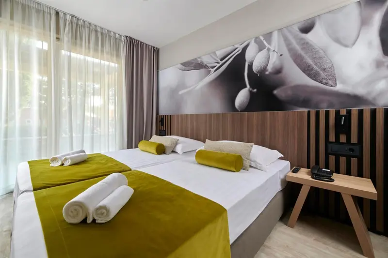 Chambre avec deux lits simples et décoration murale.