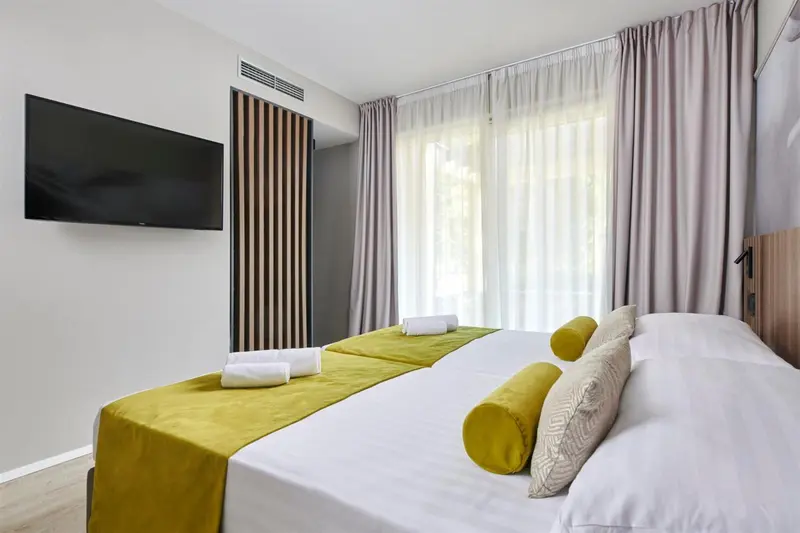 Chambre lumineuse avec deux lits simples et décoration moderne.