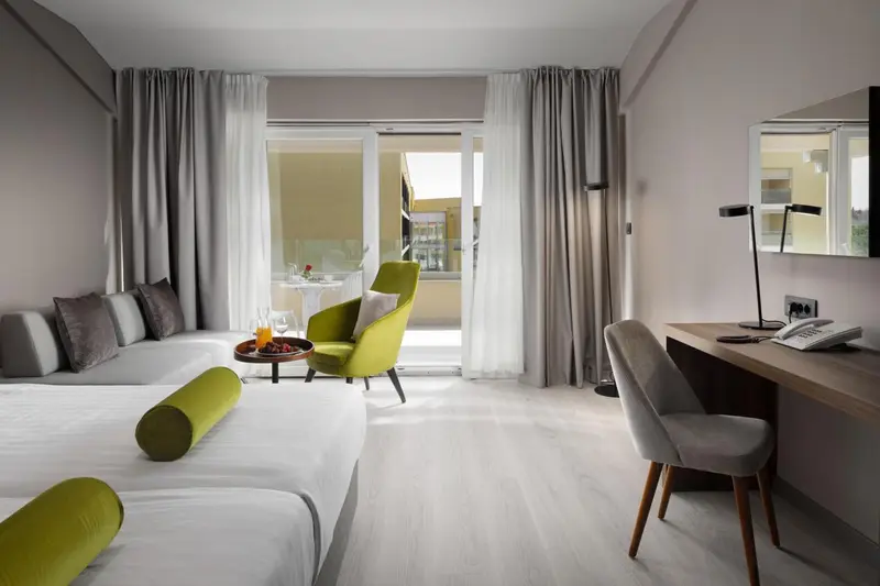 Une chambre lumineuse avec un canapé, une table et un balcon.