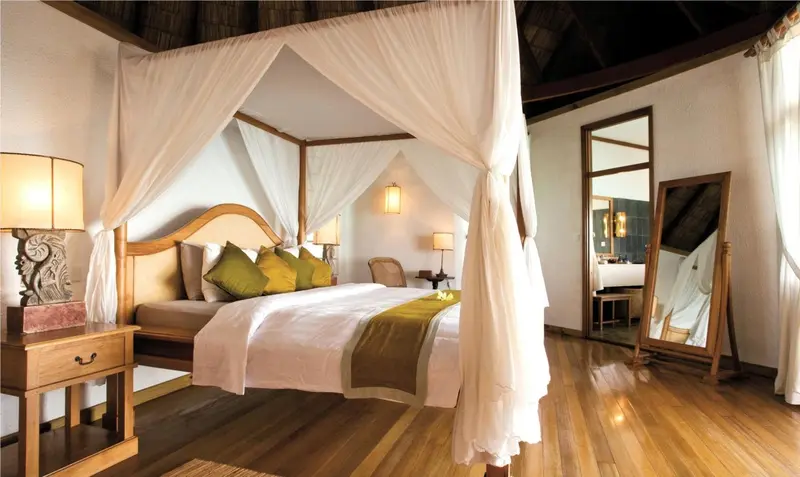 Une chambre lumineuse avec un lit à baldaquin et une décoration soignée.