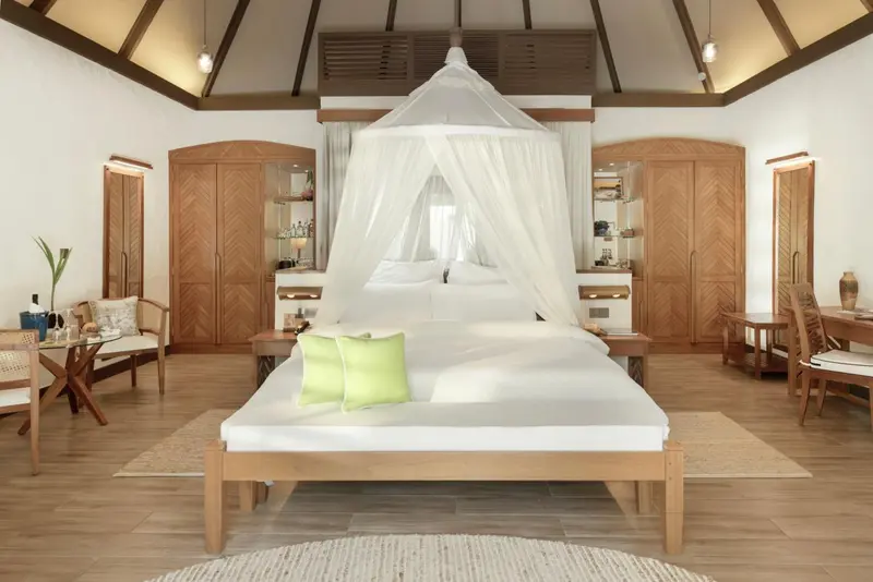 Une chambre lumineuse avec un grand lit à baldaquin et un mobilier en bois.