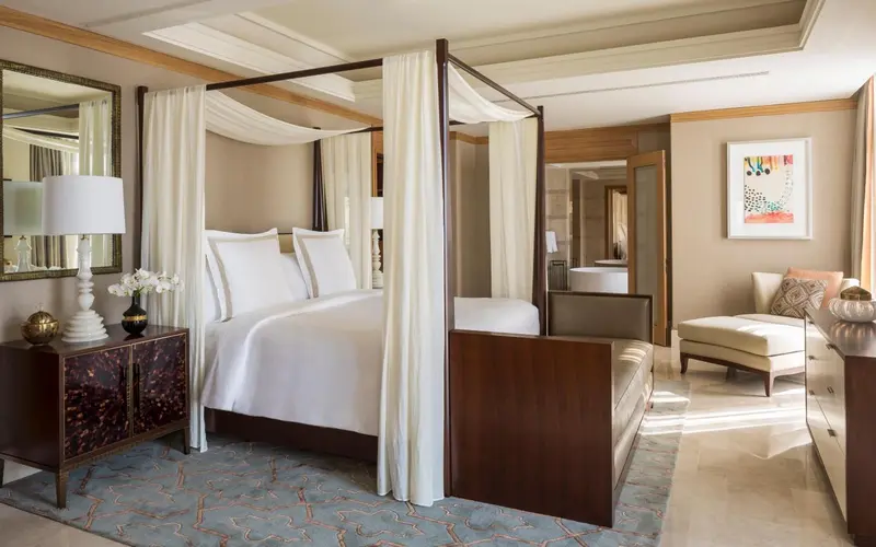 Une chambre spacieuse avec un lit à baldaquin et un coin salon.