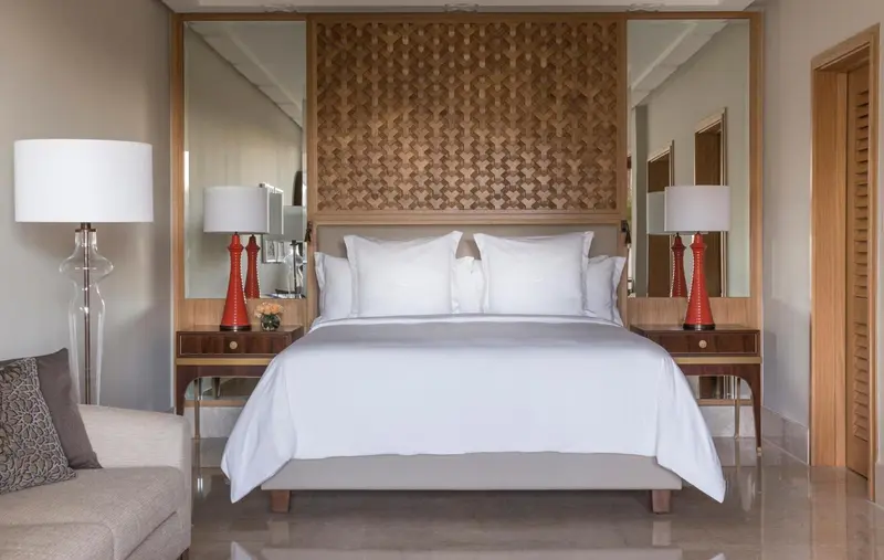 Une chambre lumineuse avec un grand lit recouvert de draps blancs.