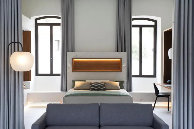 Une chambre lumineuse avec un grand lit et un canapé.