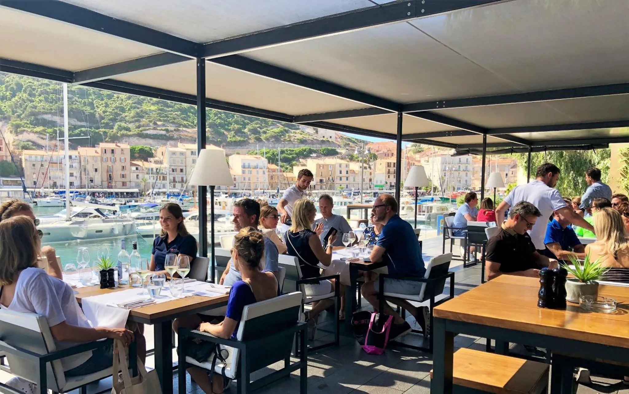 Une terrasse ombragée avec des tables et des chaises accueillant des clients.