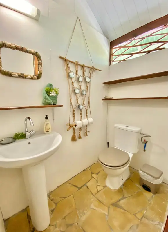 Une salle de bain lumineuse avec lavabo, miroir et toilettes.