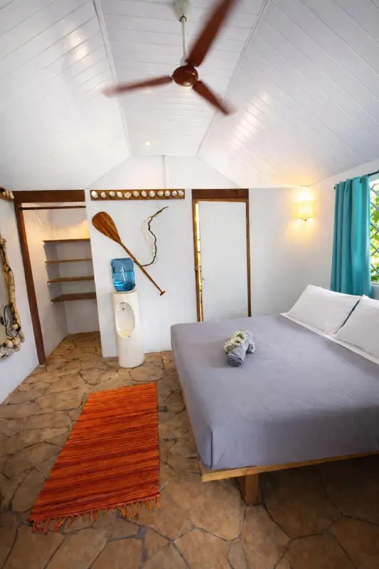 Une chambre lumineuse avec un lit simple et un tapis orange.