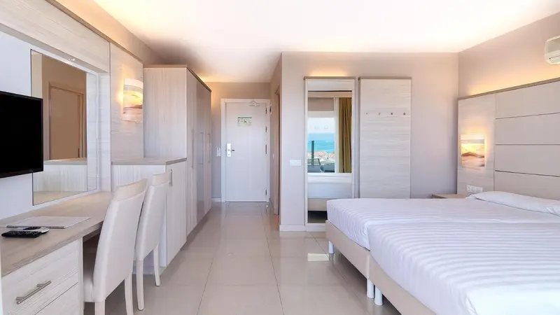 Une chambre lumineuse avec un lit double et un espace bureau.