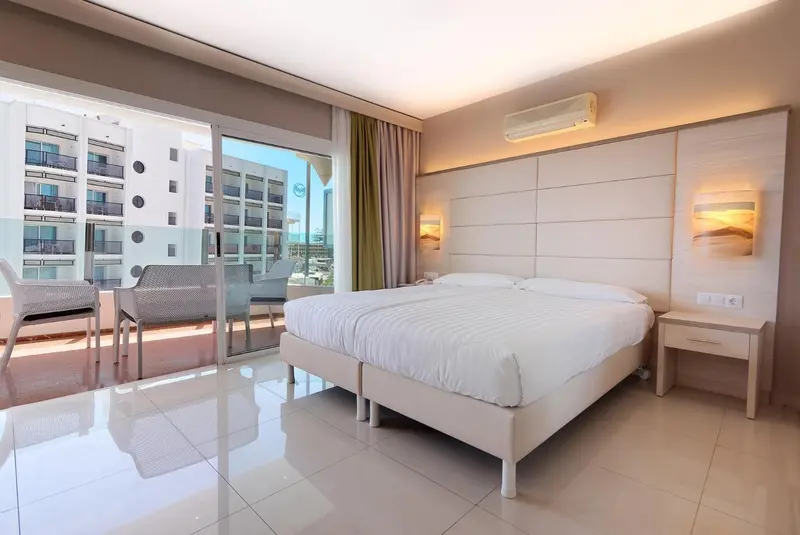 Une chambre lumineuse avec un grand lit et un accès à une terrasse.