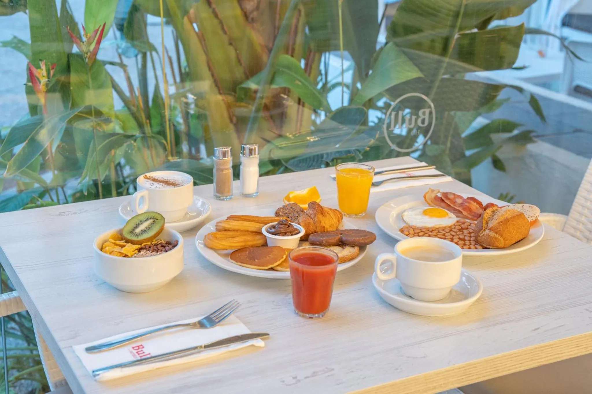 Une table est dressée avec un petit-déjeuner copieux.