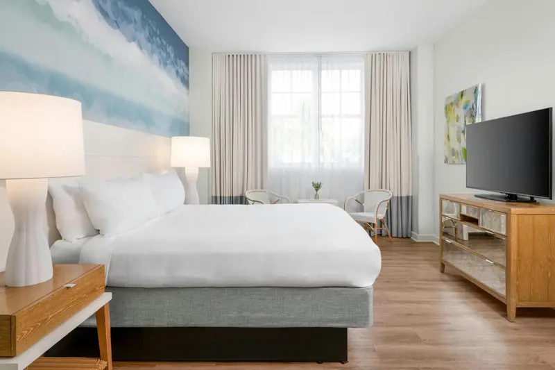 Une chambre lumineuse avec un grand lit et une décoration sobre.