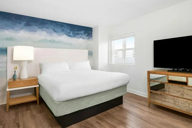 Une chambre lumineuse avec un grand lit et une décoration marine.