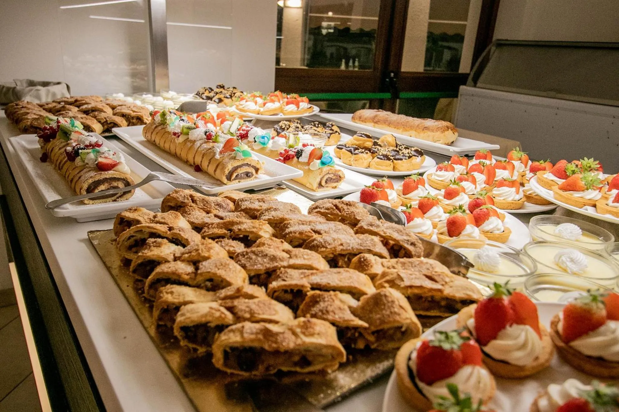 Un buffet propose une grande variété de pâtisseries et de desserts.