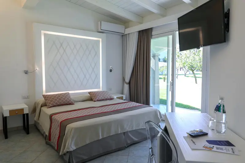 Une chambre lumineuse avec un lit double et un bureau.