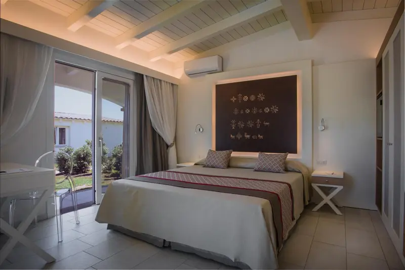 Une chambre lumineuse avec un grand lit et un accès à une terrasse.