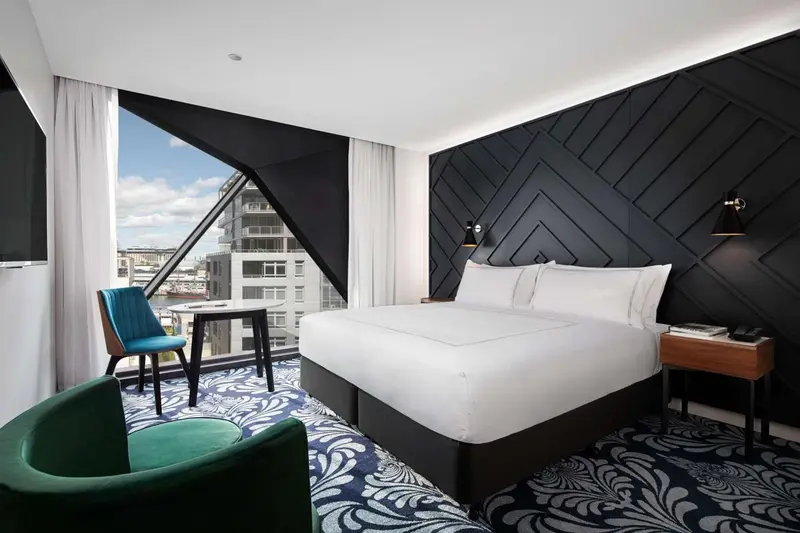 Une chambre moderne avec un grand lit et une vue sur la ville.