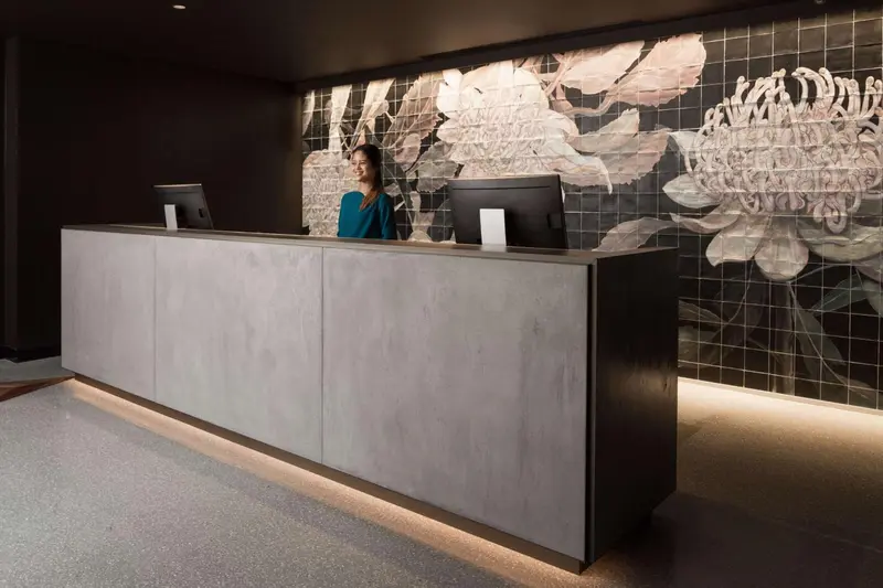 Un comptoir d'accueil moderne avec une décoration florale murale.