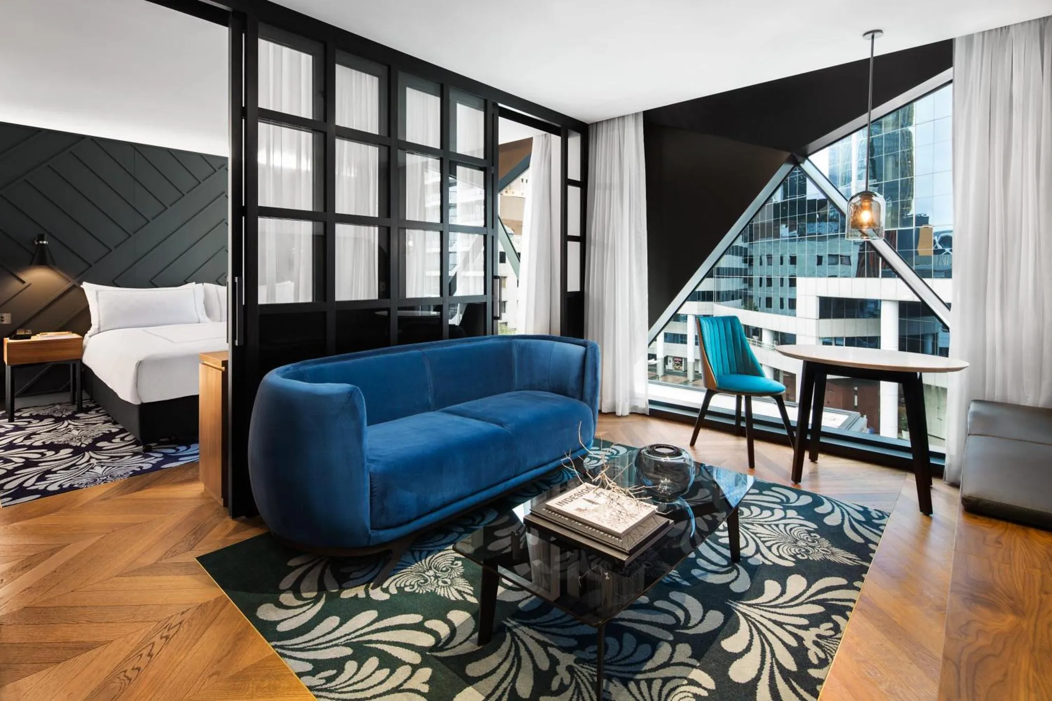 Un salon moderne avec un canapé bleu et une table basse en verre.