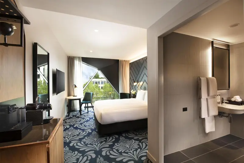 Une chambre d'hôtel moderne avec un grand lit et un coin salon.