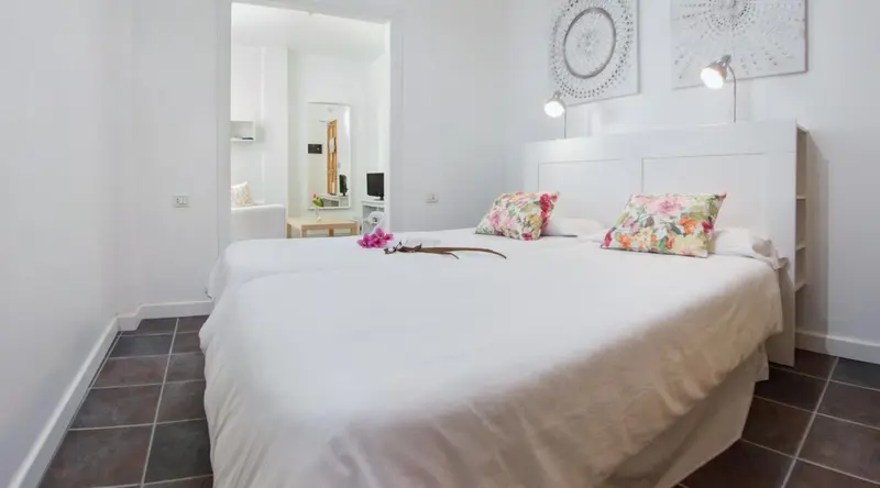 Une chambre lumineuse avec un grand lit et une décoration florale.