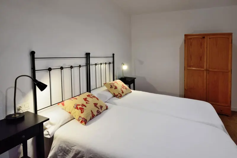 Une chambre avec un lit double et une armoire en bois.