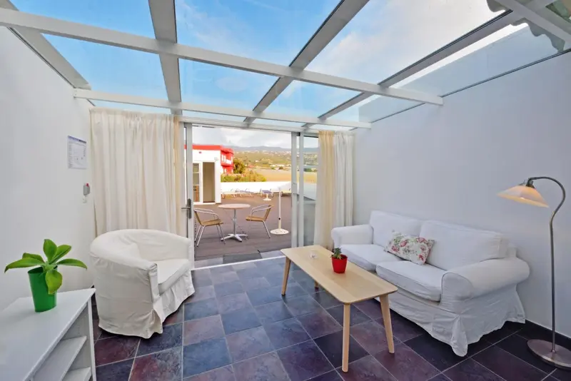 Espace de détente lumineux avec canapés et accès à une terrasse.