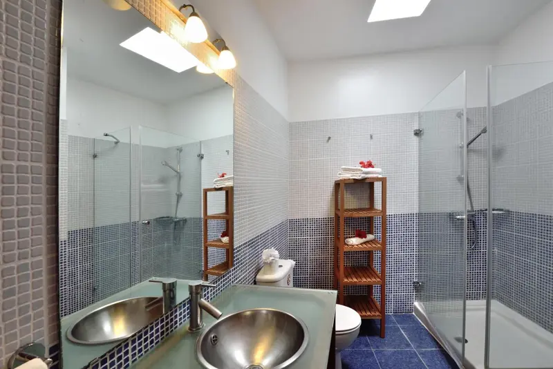 Salle de bain moderne avec deux vasques et douche à l'italienne.