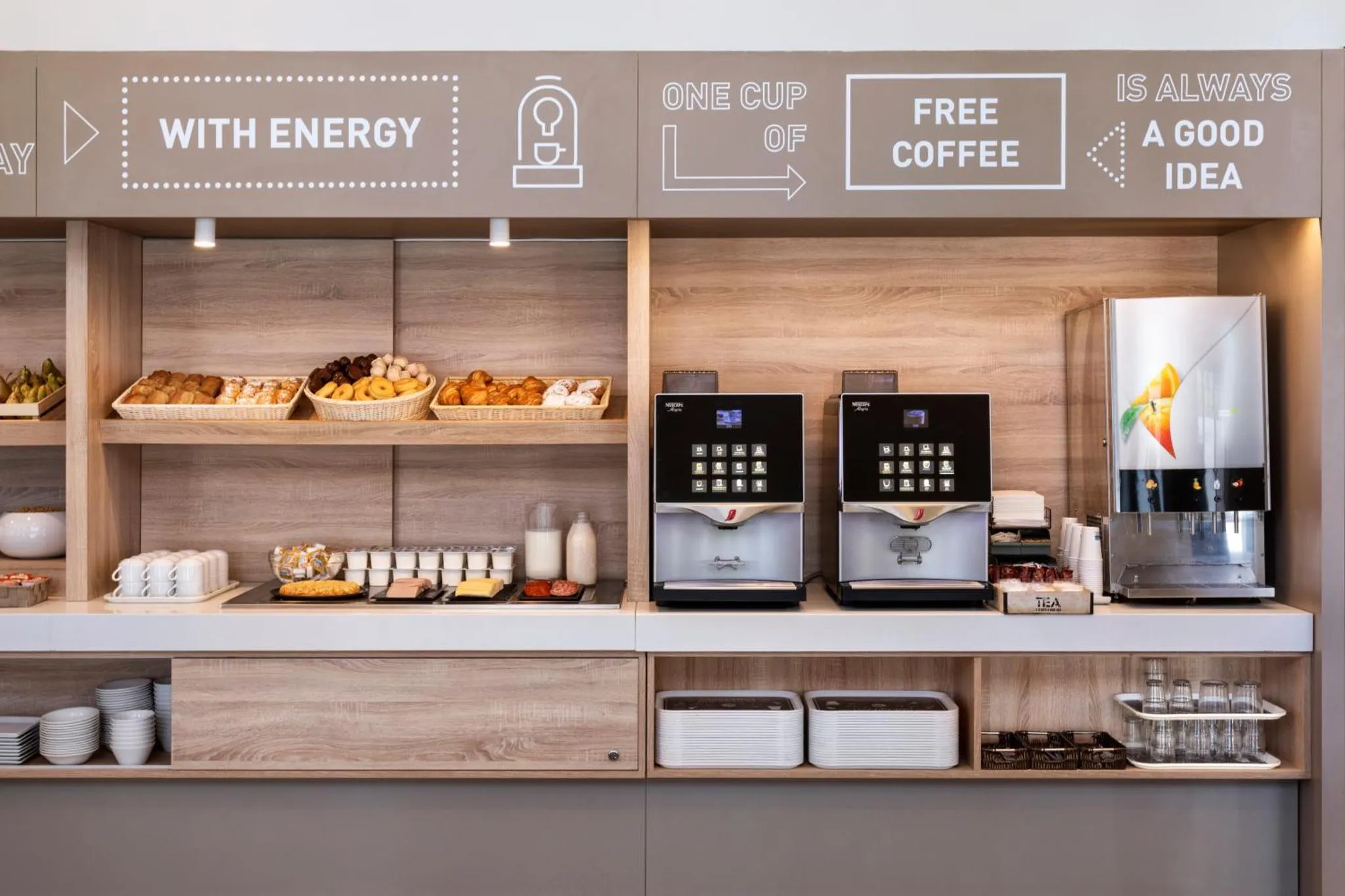 Un comptoir de buffet propose des viennoiseries, des boissons et du café.