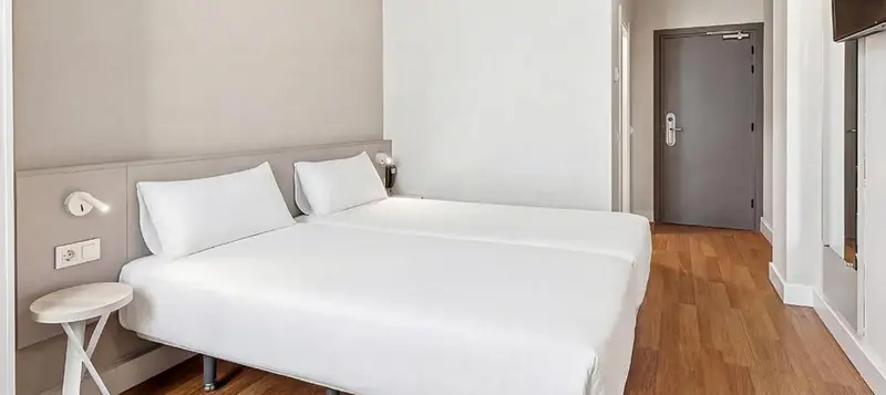 Une chambre avec un lit double et une porte sombre.