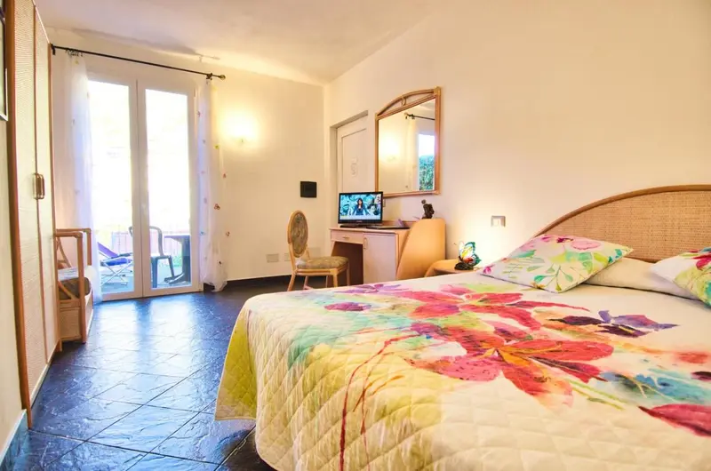 Une chambre lumineuse avec un grand lit et un accès à une terrasse.