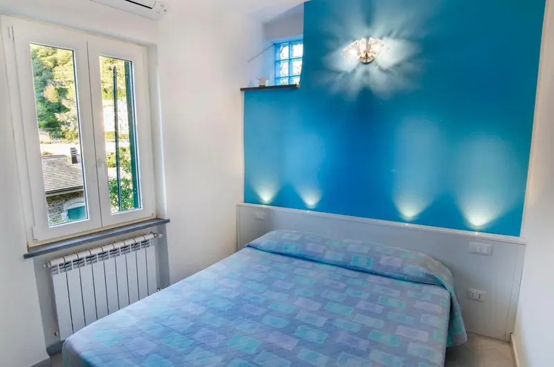 Une chambre lumineuse avec un lit et des fenêtres donnant sur la verdure.