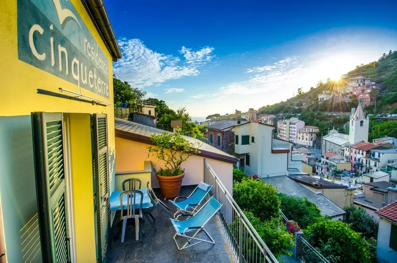Terrasse avec mobilier d'extérieur et vue sur un village en bord de mer.