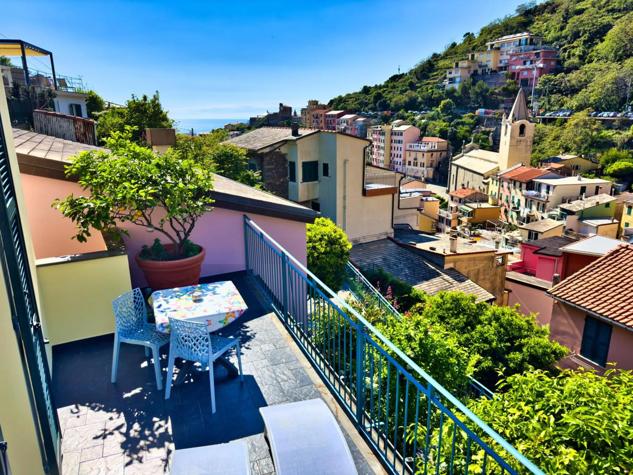 Une terrasse colorée offre une vue sur un village pittoresque en bord de mer.