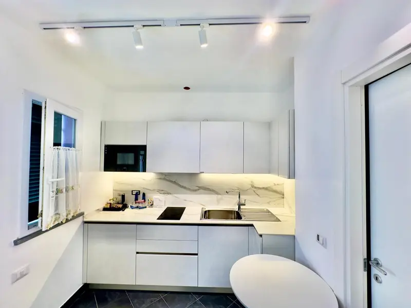 Cuisine moderne et minimaliste avec plan de travail en marbre et électroménager encastré.