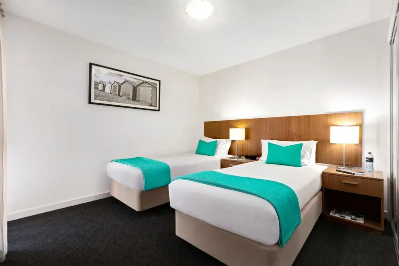 Chambre avec deux lits simples et décoration turquoise.