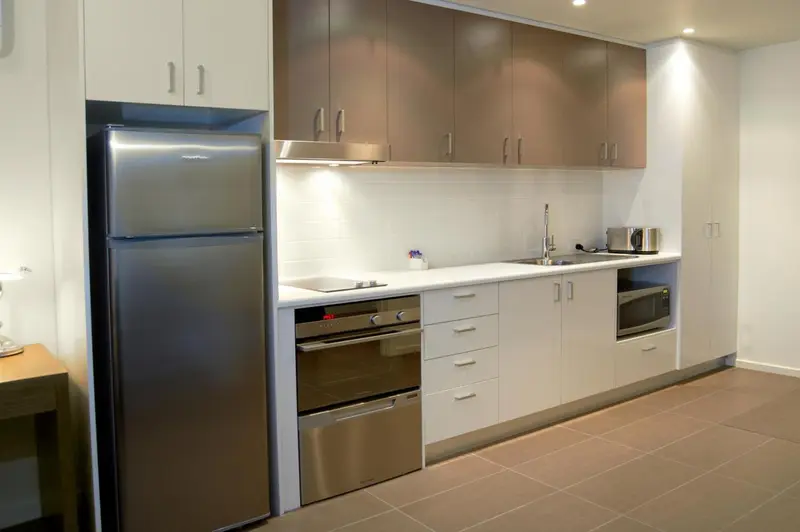 Cuisine moderne avec électroménager en inox et plan de travail clair.
