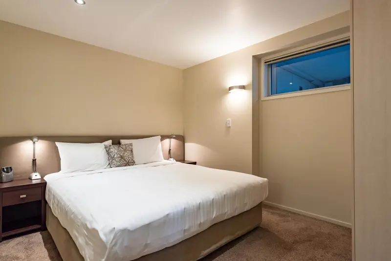 Une chambre lumineuse avec un grand lit et une fenêtre.